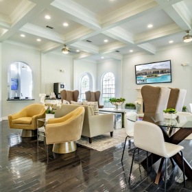 Quick access to state-of-the-art amenities a clubhouse room with a large table and chairs
