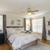 a bedroom with a nightstand, dresser and a window