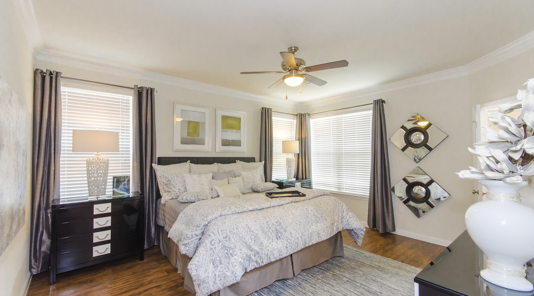 Generous bedroom offerings to fit every family a bedroom with a nightstand, dresser and a window