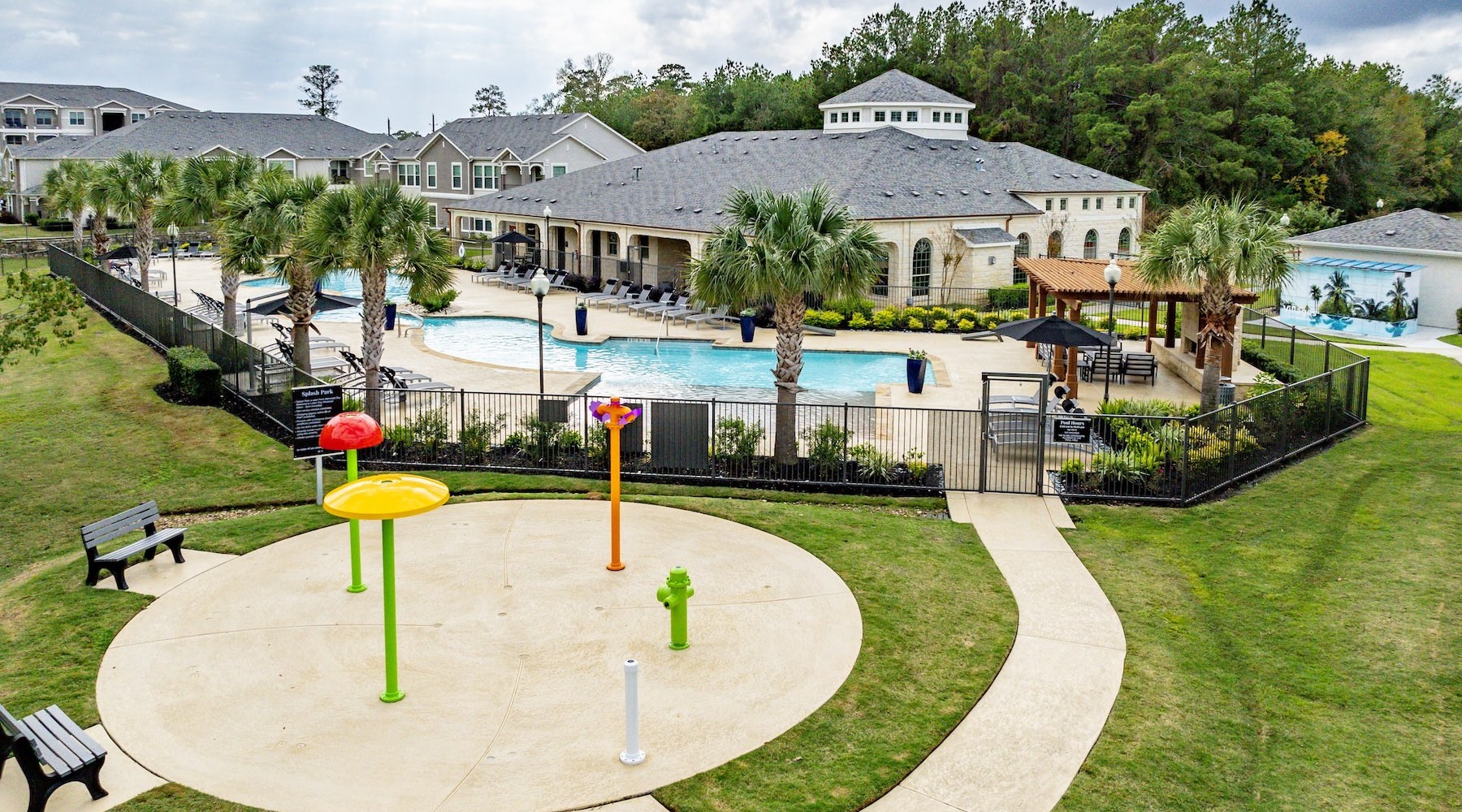Settle into comfort at Foxtail Commons a pool and a playground with a building in the background