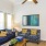 a living room with a blue couch and a fan